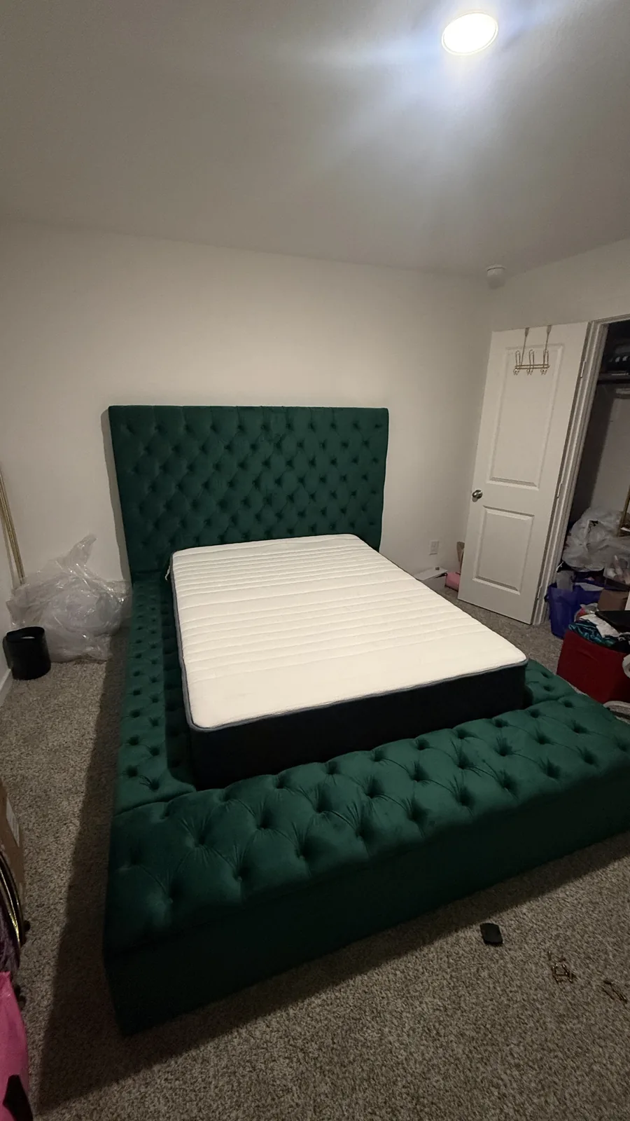 Green tufted bed frame assembled in a Houston-area bedroom