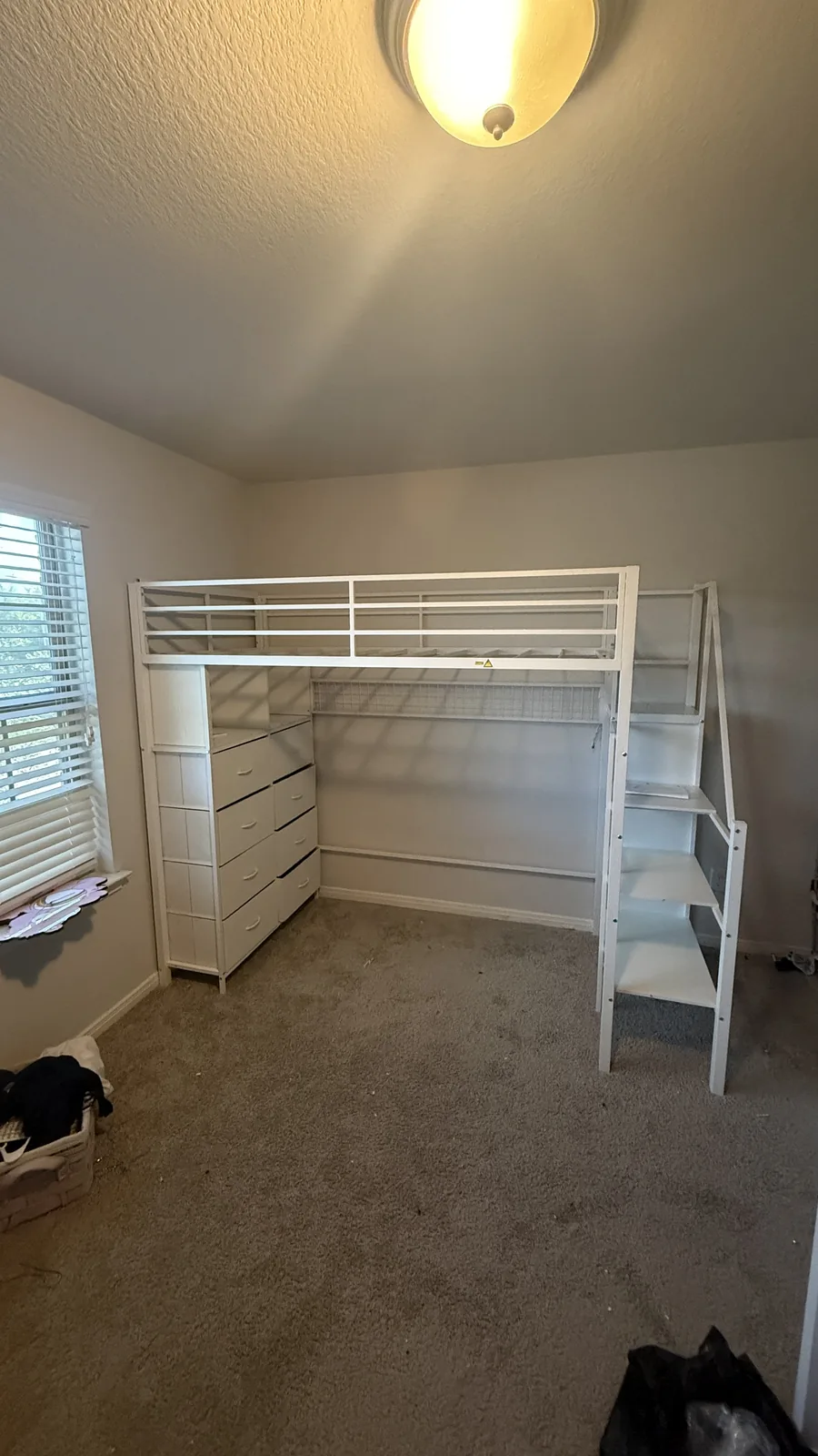 White loft bed with storage assembled in a Houston-area kids room